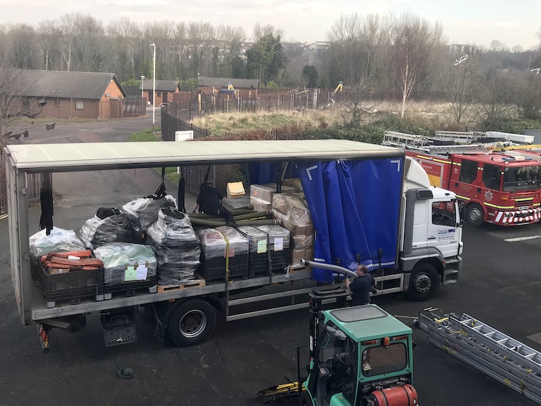 Staff at Tony Carter Transport Limited loading fire equipment onto lorry at TWFRS Stores warehouse. (TWFRS)