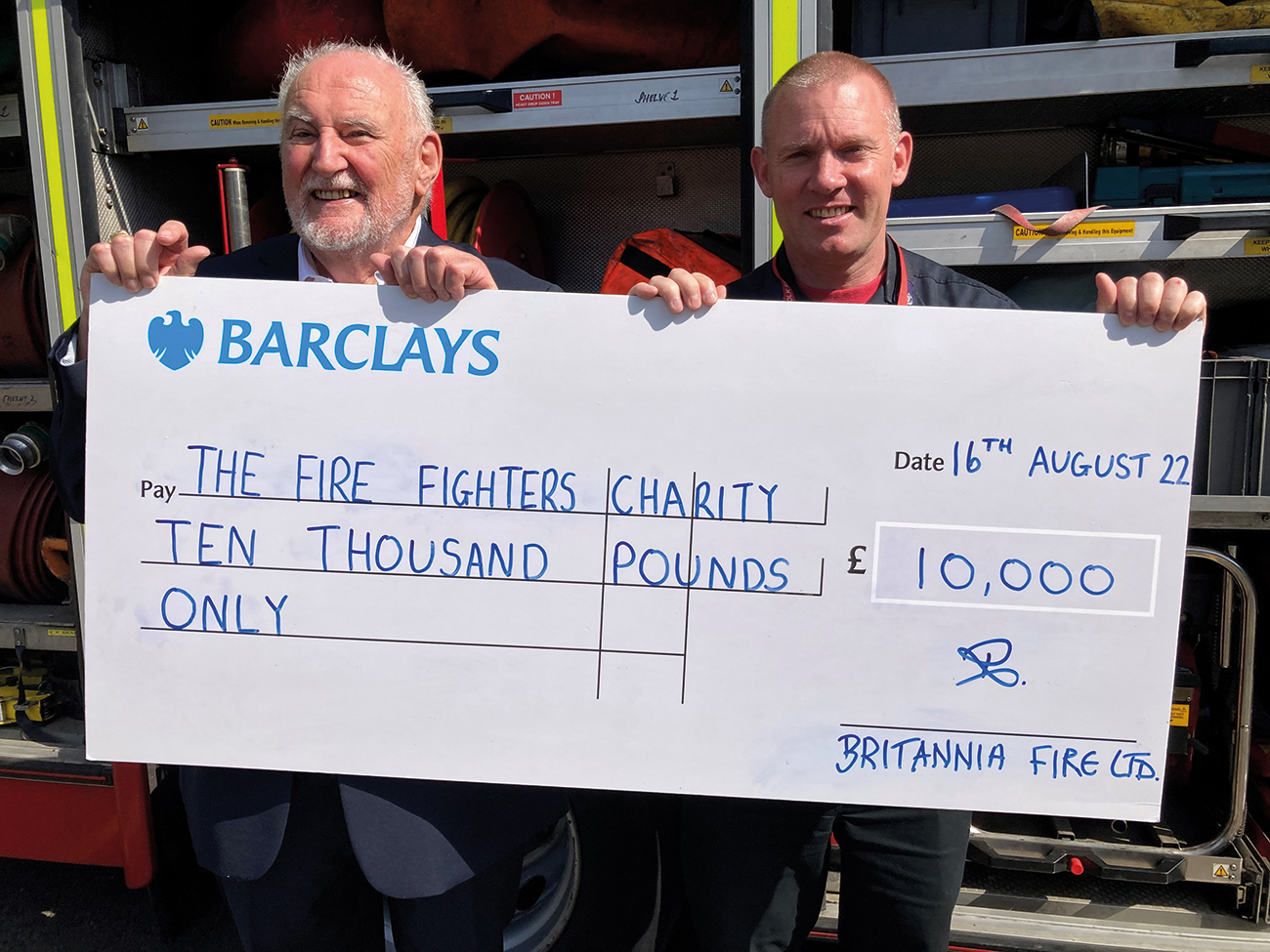 Roger Carr (left) from Britannia Fire presents a £10,000 cheque to Emyr Gough from The Fire Fighters Charity.